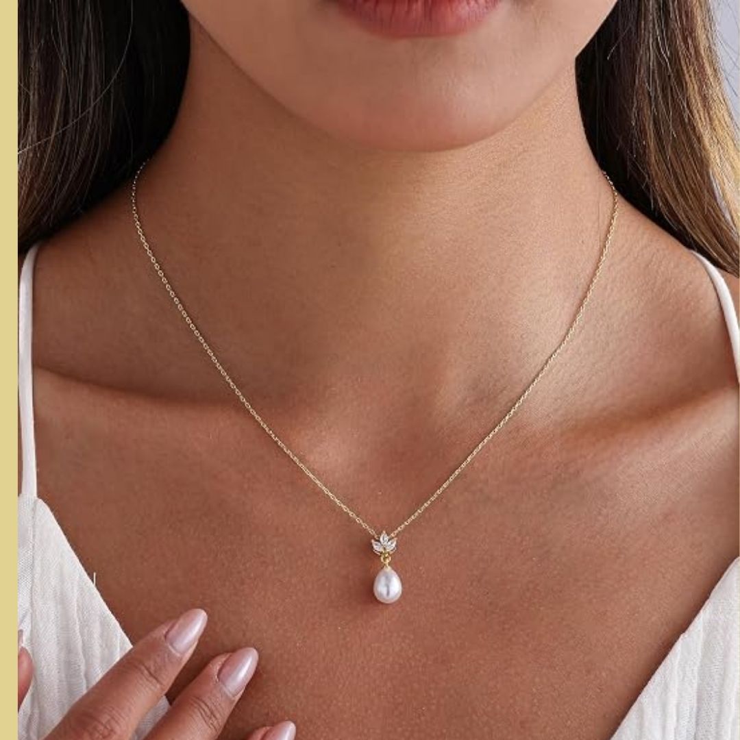 Lieke – Elegante goudkleurige ketting met druppelparel en kristallen bloemdetail