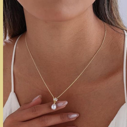 Lieke – Elegante goudkleurige ketting met druppelparel en kristallen bloemdetail